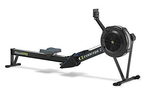 A modern American converted-garage home gym with light epoxy concrete flooring -- an air-resistance rowing machine in the foreground, a black powder-coated power rack with an Olympic barbell racked at chest height on the left, a pair of cube-style adjustable dumbbells and a black adjustable bench on the right, bright morning daylight from a side window. The realistic 2026 home gym -- not a $5,000 commercial setup, but the rower-rack-dumbbell-bench combination most US lifters actually buy under $2,500. Footprint per piece, weight capacity, and verified review depth are the three specs that determine whether a $120 CAP rack or a $990 Concept2 RowErg is actually right for your space.