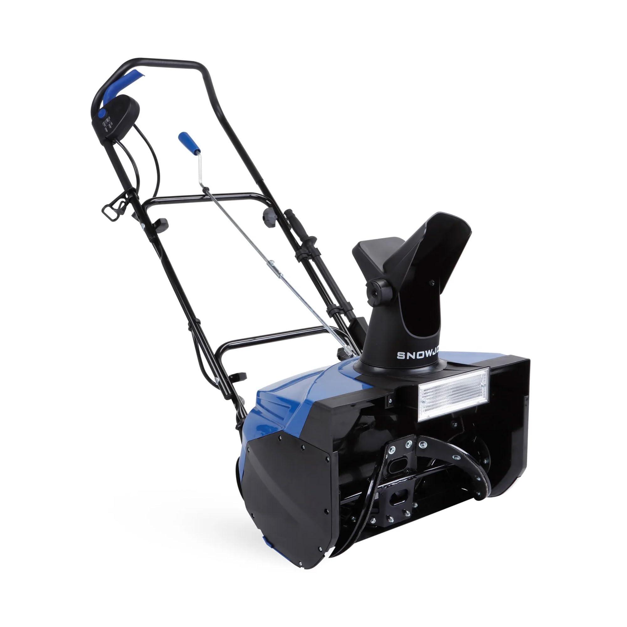 Snow Joe Ultra corded electric snow blower clearing a driveway with headlight on