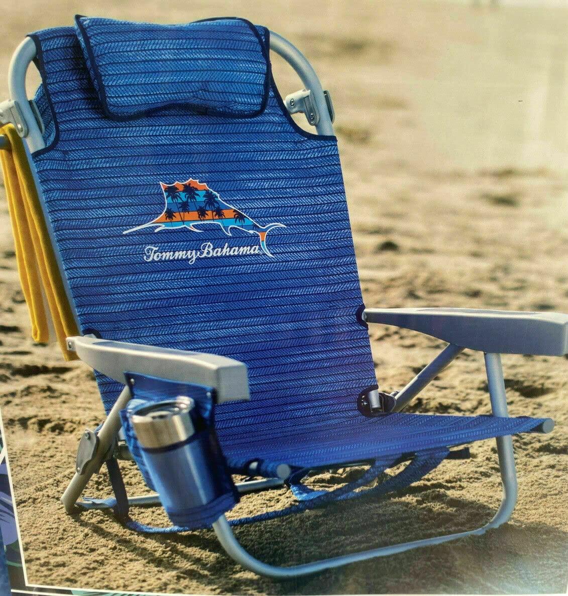 Seven beach chairs lined up on a sunny Florida beach with colorful patterns and ocean waves in the background